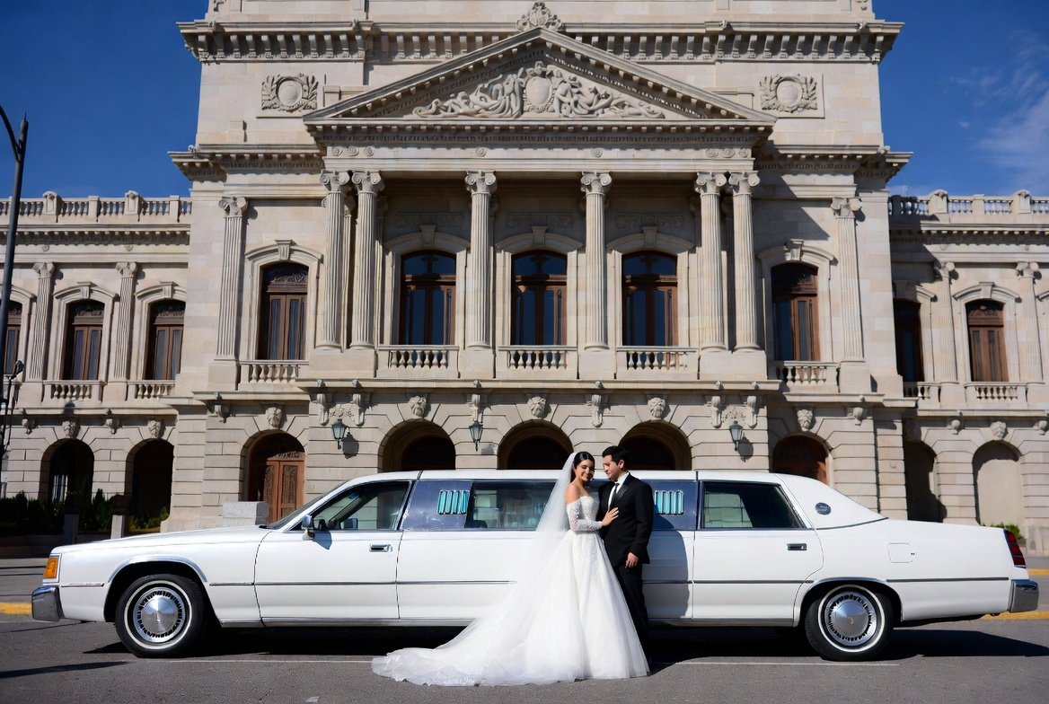 Recien casados en una limusina streech blanca